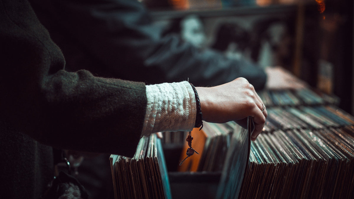 Manos buscando entre discos de vinilo en una disquería