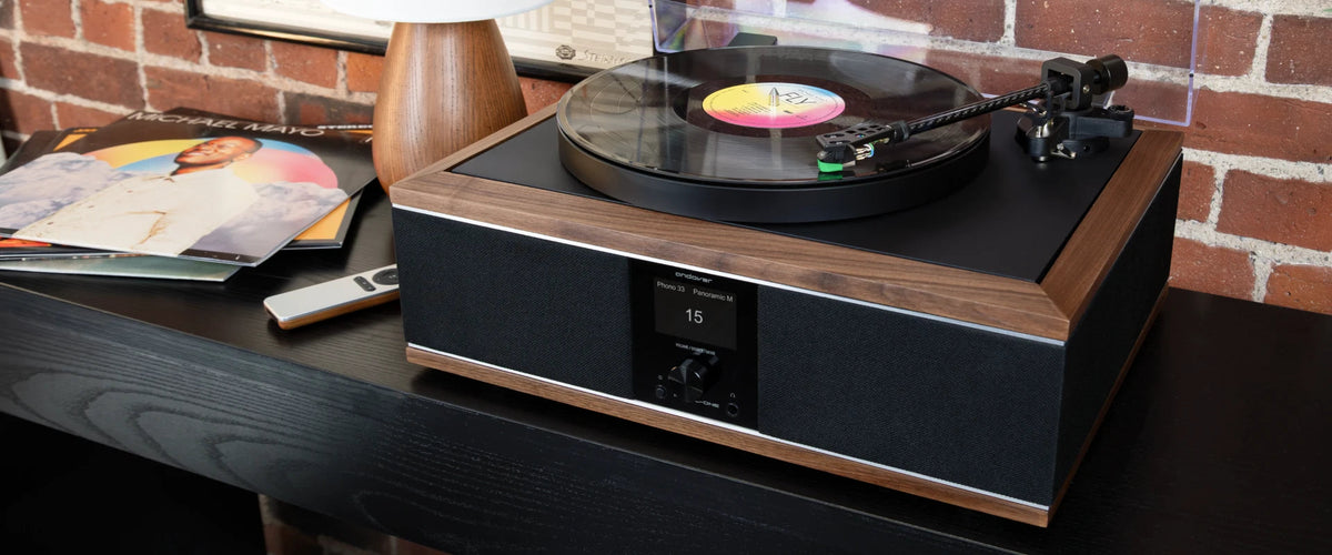 Tocadiscos Andover-One con un disco sonando en un living con pared de ladrillo