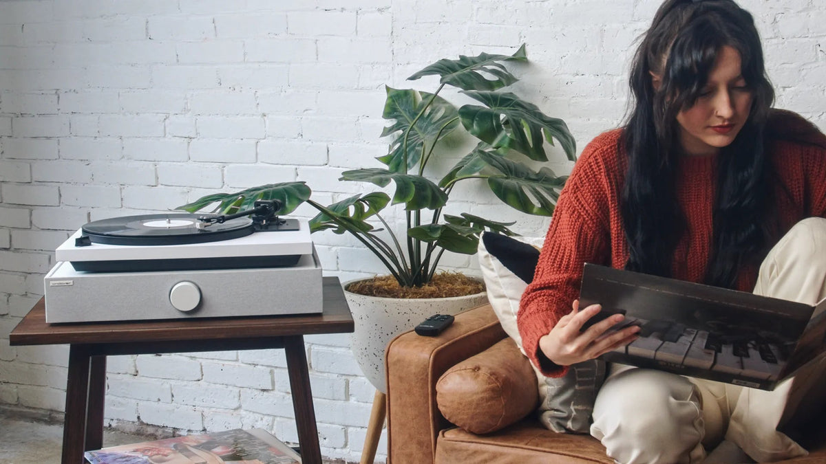 Una mujer elige un disco junto a un tocadiscos Andover